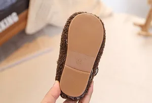 Close-up of anti-slip rubber sole with size 23 on plush faux fur winter kid shoes