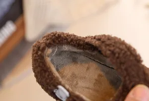 Detail view of cozy winter kids' shoes showing soft gray plush lining and brown faux fur