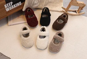 Detail view of children's fleece Mary Jane shoes in six colors on a cozy home rug