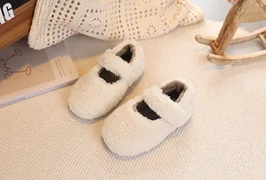 Top view of cream white plush Mary Jane kids shoes with Velcro strap on a cozy rug