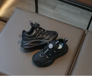 Detailed close-up of the automatic rotary buckle system on black kids' sneakers