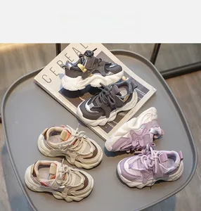 Drei Paar atmungsaktive Kinder-Sneaker aus Mesh in Grau Beige und Lila auf einem Tablett