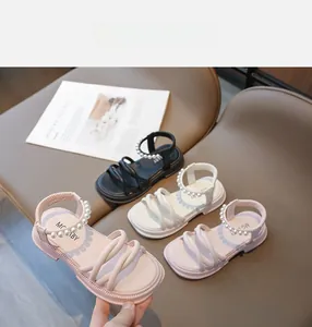 Dettaglio di sandali per bambini con perle in rosa, bianco e nero con suole spesse antiscivolo