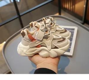 Nahaufnahme atmungsaktiver Kinder-Sneaker mit Klettverschluss und orangenen Akzenten