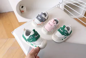 Detail of baby walking shoes with rubber toe protection and cute dinosaur design