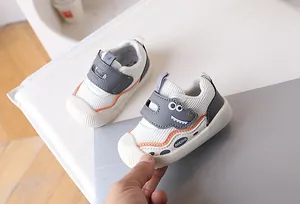 Detail view of baby walking shoes with cute dinosaur pattern and hook and loop closure