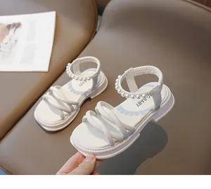 Dettaglio di sandali bianchi per bambina con cinturini di perle e suola spessa