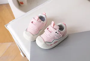 Detail of pink baby walking shoes with cute dinosaur design and anti-slip rubber toe cap
