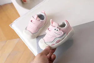 Detailed view of baby walking shoe with breathable mesh, soft pink design, and dinosaur motif