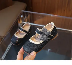 Detail of glitter girl Mary Jane shoes with mesh bow and scalloped trim on rubber sole