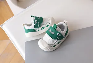 Detail of baby walking shoe showing breathable mesh and green dinosaur velcro strap