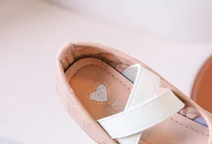 Dettaglio ballerina rosa da bambina con motivo trapuntato e cinturini elastici incrociati