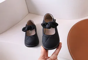Dettaglio scarpe Mary Jane nere con trama trapuntata e fiocco 3D per bambine