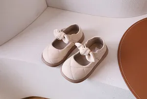Dettaglio di scarpe Mary Jane trapuntate beige con fiocco e suola spessa in gomma