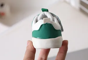 Close-up of baby sneaker heel with green synthetic leather and white mesh fabric stitching