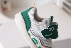 Detail view of toddler dinosaur shoes featuring corduroy fabric and velcro strap