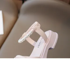 Dettaglio di sandali rosa da bambina con cinturino in perle e suola spessa antiscivolo