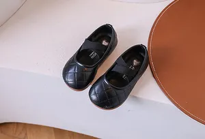 Dettaglio delle scarpe Mary Jane trapuntate nere per bambine con cinghie elastiche incrociate