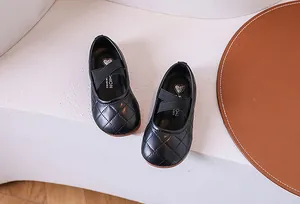 Dettaglio di scarpe Mary Jane nere trapuntate per bambine con cinturini elastici