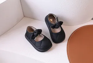Dettaglio di scarpe Mary Jane trapuntate nere per bambine con fiocco e velcro