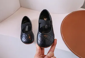 Dettaglio di scarpe Mary Jane nere per bambina con texture trapuntata e cinturini incrociati