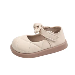 Scarpe Mary Jane beige per bambine con fiocco e trama trapuntata su sfondo bianco