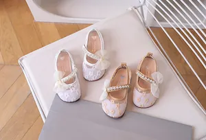 Detailed view of kids lace Mary Jane shoes with mesh bows and pearl straps
