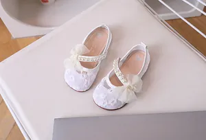 Detail of girls mesh princess shoe with lace flowers, pearls and a large mesh bow