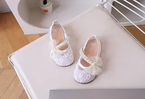Detailed top view of girls' white lace Mary Janes with pearls and tulle bow