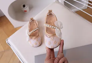 Detail of girls princess shoes with daisy lace embroidery, pearls, and mesh bow