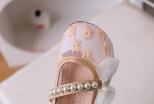Detail of girl princess mesh shoe with embroidery, white pearls and delicate bow accent