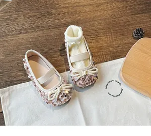 Detail of pink gold sequin Mary Jane shoes for girls featuring a white bow and elastic strap