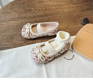 Detail of girls' champagne sequin Mary Jane shoe with rhinestone bow and elastic strap