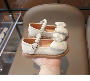 Détail de chaussures Mary Jane ivoire pour filles avec nœud et bride en perles