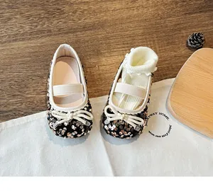 Detailed view of girls' glitter Mary Jane flats with bow detail and elastic strap