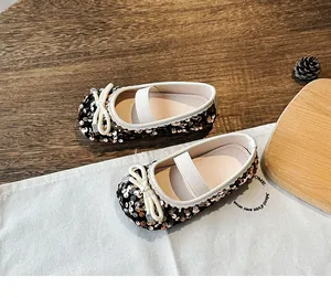 Detail of girls glitter Mary Jane flat with rose gold sequins and white ribbon bow