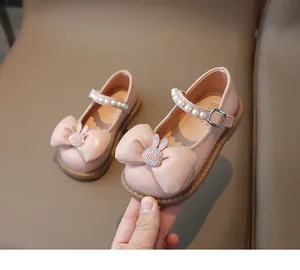 Vue détaillée de chaussures de princesse roses pour filles avec perles et nœud lapin