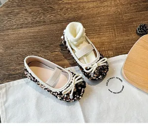Top view of girls' glitter Mary Jane shoes with black sequins and white bow detail