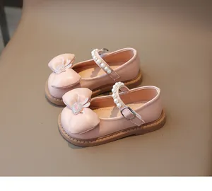 Vue détaillée des babies roses pour filles avec bride perlée et nœud décoratif
