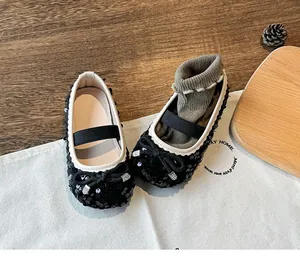 Detail of girls black sequin Mary Jane shoes with bow decoration and elastic strap