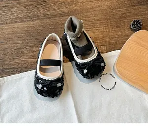 Detail of girls black sequin Mary Jane shoes with bow decoration and elastic strap