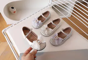 Détail de chaussures pailletées pour filles avec nœuds en dentelle et strass élégants