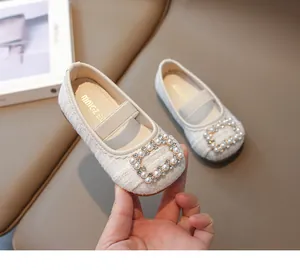 Detalle de zapatos Mary Jane de tweed para niña con hebilla de perlas y pedrería
