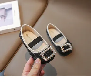 Detalle de zapatos Mary Jane de tweed negro para niña con hebilla de perlas cuadrada