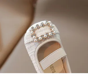 Detalle de zapato Mary Jane de tweed para niña con hebilla de perlas y pedrería