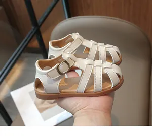 Detailed side view of off-white faux leather girls sandals with vintage metal buckle