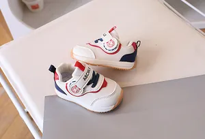 Dettaglio di scarpe per bambini con suola in gomma antiscivolo e cinturini in velcro bianchi