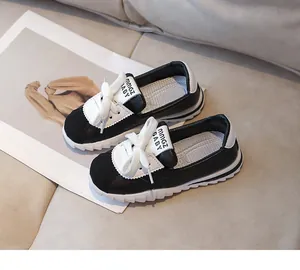 Vue détaillée de baskets pour enfants en cuir noir et blanc avec semelle épaisse crantée
