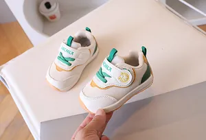 Dettaglio di scarpa primi passi per neonati con velcro e decoro mela cartoon