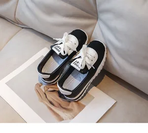 Vue de dessus des baskets en toile noir et blanc pour enfants avec lacets blancs